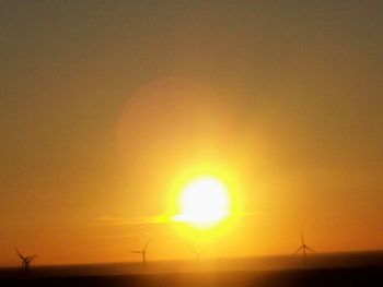 Silhouette landscape against orange sky