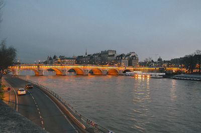 Bridge over river in city against clear sky