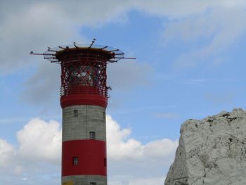 Low angle view of lighthouse by building against sky