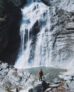 Rear view of person looking at waterfall