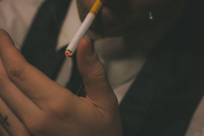 Midsection of businessman smoking cigarette