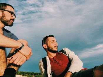 Low angle view of man looking at camera against sky