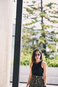 Portrait of woman standing against window