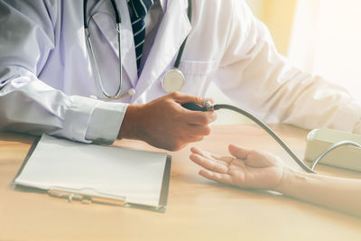 Midsection of man holding hands on table