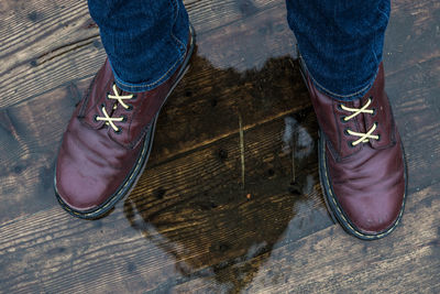 Low section of woman standing on wooden floor