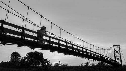 Low angle view of man on bridge against sky