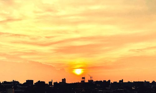 Silhouette buildings against sky during sunset