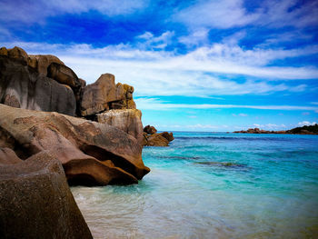 Rock formation on beach against sky