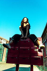 Portrait of young woman sitting on bench