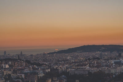 High angle view of illuminated cityscape against sky during sunset