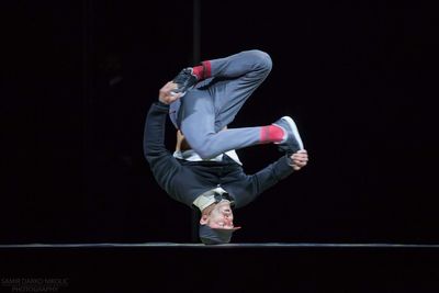 Full length of a man skateboarding on black background