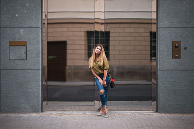 Full length portrait of woman against building