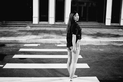 Portrait of woman standing on zebra crossing