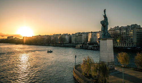 Statue of buildings against sky during sunset