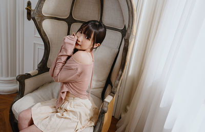 Portrait of young woman standing at home