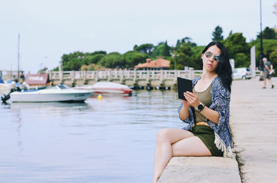 Portrait of smiling young woman sitting on water