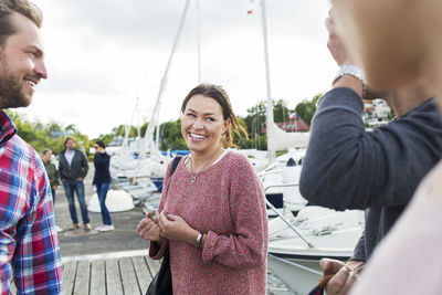 Happy woman talking to friends on pier