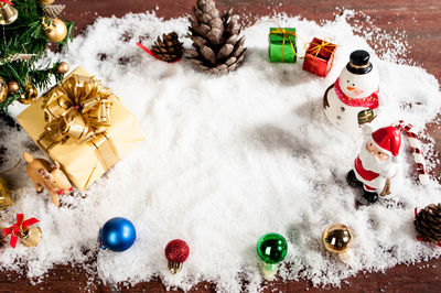 High angle view of christmas decorations with snow on table