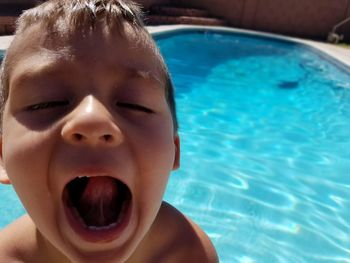 Close-up portrait of happy boy in swimming pool