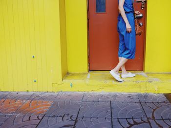 Low section of person standing on yellow door