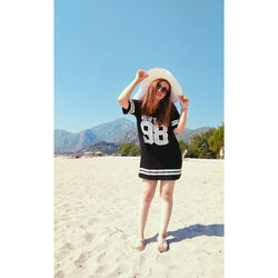 Full length portrait of young woman standing on beach