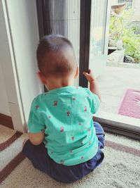 Boy sitting by window at home