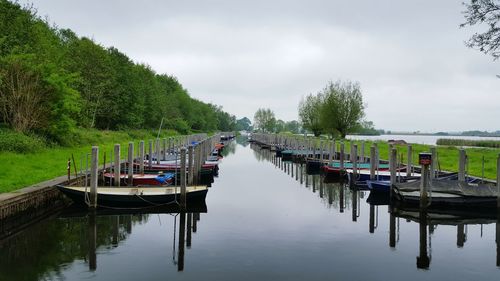 Boats moored in lake against sky