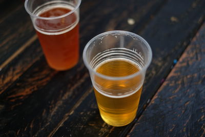 Beer in disposable glasses on wooden table