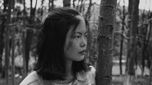 Close-up portrait of young woman looking away outdoors