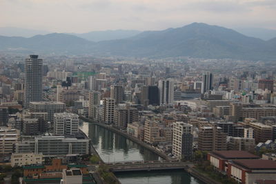 Aerial view of buildings in city against sky