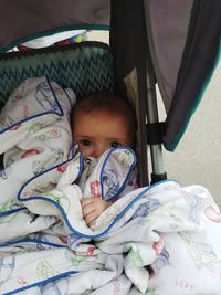 Portrait of cute baby lying in stroller