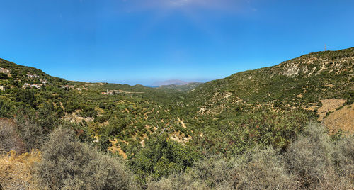 Scenic view of mountains against blue sky