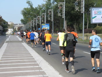 Rear view of people walking on road