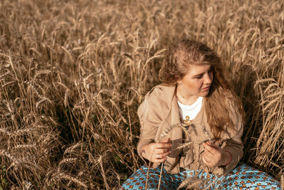 Portrait of young woman sitting on hay