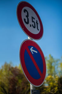 Close-up of road sign against blue sky