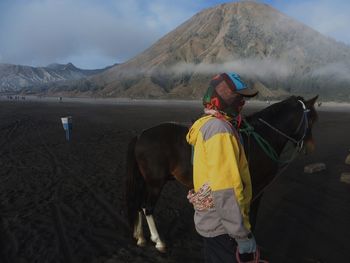 Rear view of man riding horse on mountain