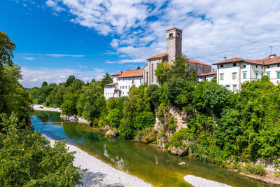 River amidst trees and buildings against sky