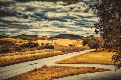 Road by landscape against sky