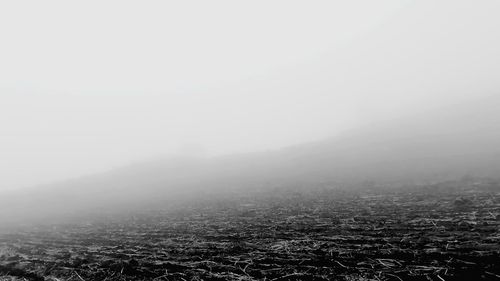 Scenic view of landscape against sky in foggy weather