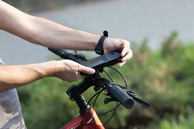 Midsection of man riding bicycle on mobile phone