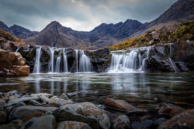 Scenic view of waterfall against sky