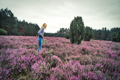 Woman standing on land amidst flowering plants