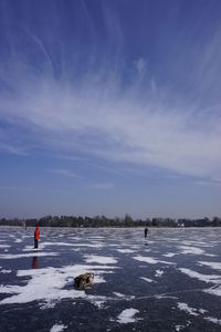 Person standing on snow covered land against sky