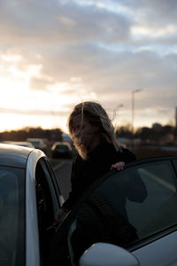 Side view of woman looking through car