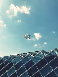 Low angle view of seagulls flying against sky