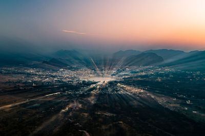 High angle view of illuminated cityscape against sky during sunset