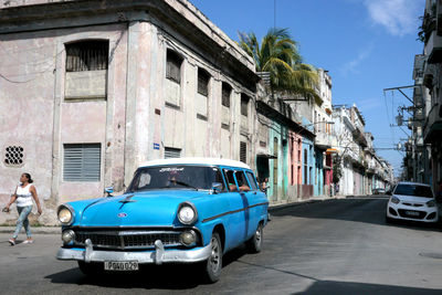 Cars on street by buildings in city