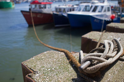 Close-up of rope tied to cleat at harbor