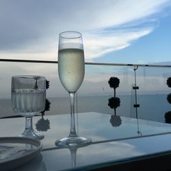 Close-up of champagne flute on table against sky during sunset