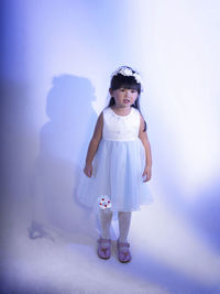 Full length of cute girl standing against white background